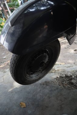 Monokrom tekerlek detayı, eski mobilet tasarımını ve desenini beton bir yüzey üzerinde yakalar