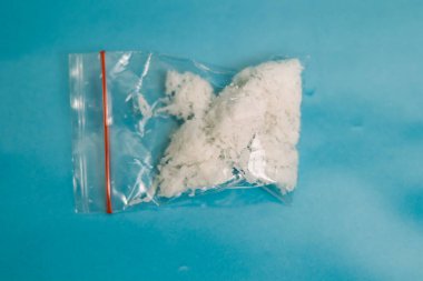 Paramparça hindistan cevizi parlak mavi bir arka planda temiz bir plastik torbaya mühürlendi.