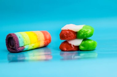 Canlı tatlılar, zıt bir arka plana karşı eğlenceli bir kompozisyon oluşturur, neşe uyandırır.