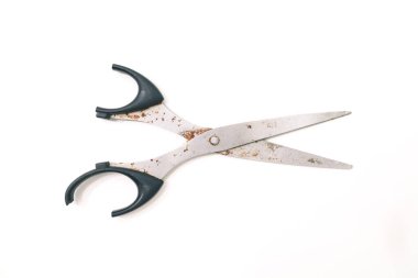 Temiz beyaz bir yüzeye izole edilmiş eski ve paslı bir makas, tasarım projeleri için mükemmel.