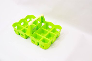 Canlı limon yeşili plastik yumurta tutacağı temiz beyaz arka planda izole edilmiş.