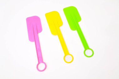 Canlı pembe, sarı ve yeşil renkte pişirmek ve pişirmek için renkli plastik spatulalar.