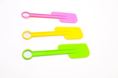 Pırıl pırıl parlayan silikon spatula üçlüsü saf beyaz arka planda ustalıkla dizilmiş.