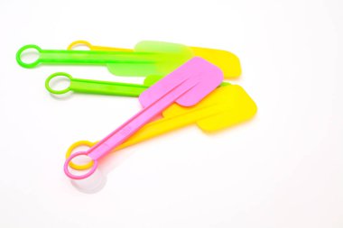Beyaz arka planda pişirme ve pişirme için üç renkli silikon spatula