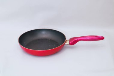 Yapışmayan bir yüzeyi olan kırmızı bir tava, günlük yemek ihtiyaçları için ideal.
