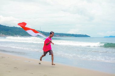 Endonezya Bağımsızlık Günü 'nü tropikal plajda kırmızı ve beyaz bayrak ile kutluyoruz.
