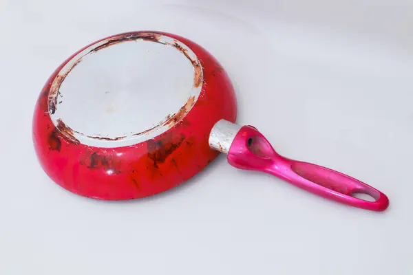 Beyaz arka planda pembe saplı kullanılmış kırmızı bir tavanın yakın çekimi