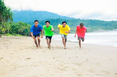 Canlı Tişörtlü Dört Adam Tropik Plajda Koşuyor