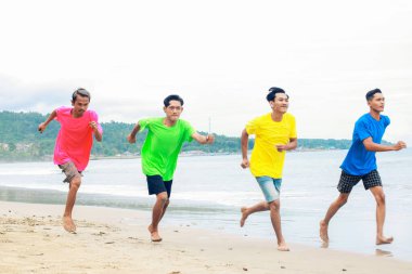 Neşeli Arkadaşlar Sahilde Parlak Gök Altında Canlı Tişörtler Kıyı Sahilinde Birlikte Koşarlar