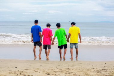 Parlak Gökler Altında Genç Arkadaşların Sahil Muhabbeti Canlı Gömlekler El ele tutuşuyor