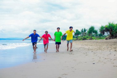 Dört genç adam sahilde bir günün tadını çıkarıyor.
