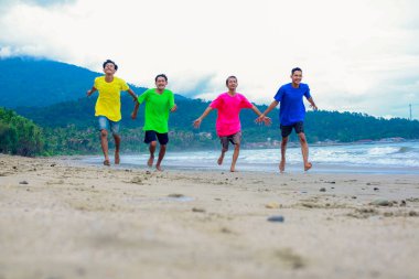 Dört Genç Kum Kumsalında Keyifle Koşuyor
