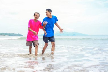 İki adam plaj gününün tadını çıkarıyor.