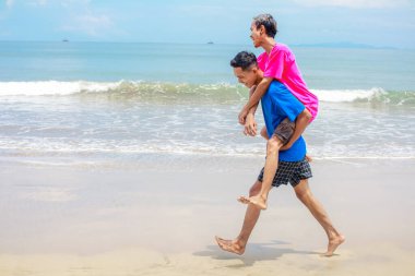 Mutlu çift plaj gezintisinin tadını çıkarıyor.