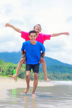 Tropik bir plaj gününün tadını çıkaran iki genç adam.