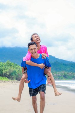 Tropik Sahilde Neşeli Arkadaşlar İki Genç Adam Sırtında Yolculuğun Tadını Çıkartıyor