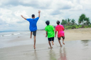 Neşeli bir şekilde Sunny Beach 'te oynayan üç genç adam