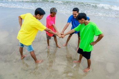 Canlı Gömlekli Dört Genç Kumsalda Takım Çalışmasını Kutla