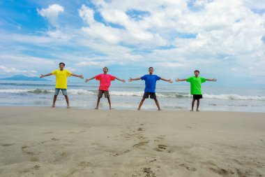 Kumsalda güneşli bir günün tadını çıkaran dört kişi.