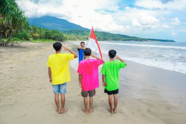 Tropik Plajda Ulusal Bayrağı Selamlayan Dört Genç Adam