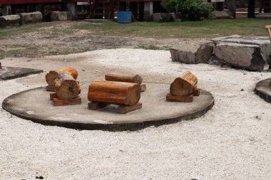 Beton bloknotların üzerinde kütük bankları olan bir buluşma noktası kırsal bir oturma alanı sunar