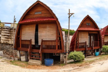 Kırmızı çatıları olan eşsiz ahşap bungalovlar. Rahat tropikal bir kaçış için mükemmel.