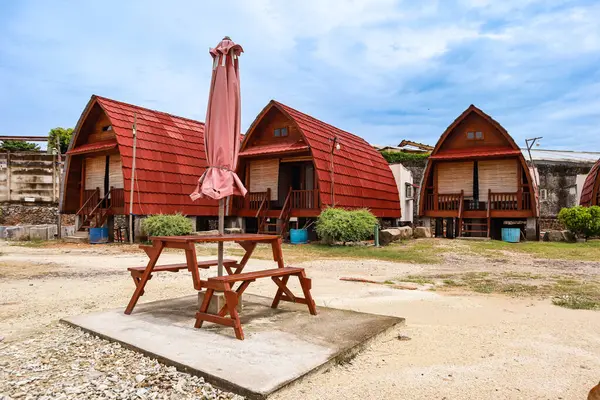 Kırmızı çatıları olan büyüleyici ahşap kamaralar tropikal bir cennette huzurlu bir geri çekilme sunuyor.