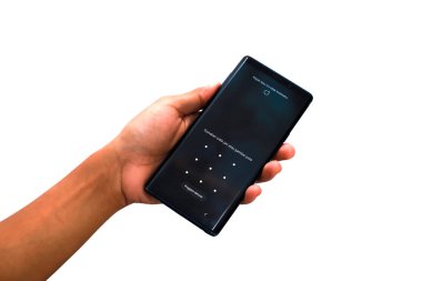 Temiz, beyaz bir arkaplan üzerinde güvenlik desenli kilit ekranı olan akıllı telefonu tut.
