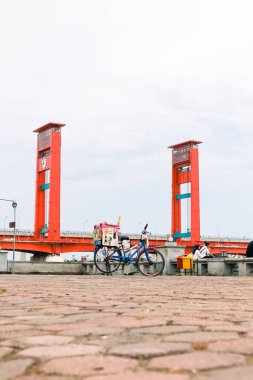 Palembang 'taki Ampera Köprüsü. Ön planda bir satıcının bisikleti var..