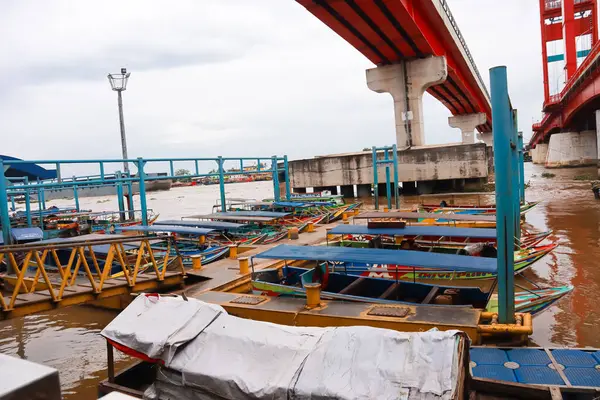 Palembang Endonezya 'daki modern bir köprünün altında hareketli bir nehir limanı bulunuyor..