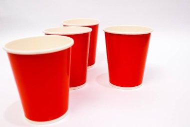 Beyaz bir yüzeyde duran dört kırmızı bardak bir parti ya da etkinlik ayarını işaret ediyor.