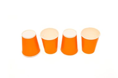 Beyaz zemin üzerinde dört adet turuncu kağıt bardak, tasarım elemanları ve modeller için ideal.