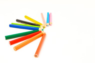 Beyaz bir yüzey üzerinde yarı daire şeklinde dizilmiş renkli kalemler, okul veya sanat kavramları için idealdir.