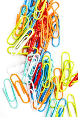 Renkli ataçlardan oluşan canlı bir parça temiz beyaz bir zemine saçılmış.