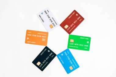 Temiz beyaz bir zemin üzerinde birbirini çevreleyen hareketli bir kredi kartı dizisi