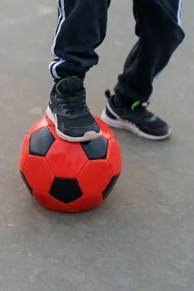 サッカーボールの上に男の子の足のクローズアップ — ストック写真
