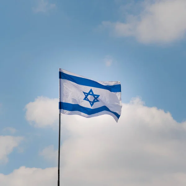 Die Israelische Flagge Weht Einem Sonnigen Tag Wind Vor Blauem lizenzfreie Stockfotos