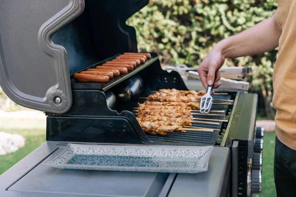 Hand Young Man Grilling Meat Skewers Sausage Huge Gas Grill — Stock Photo, Image