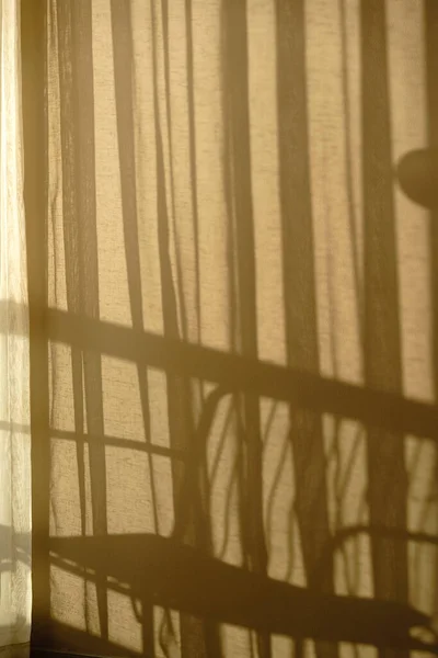 stock image Window and sunrise light, shadows and tulle curtain on beige background casting shadows.