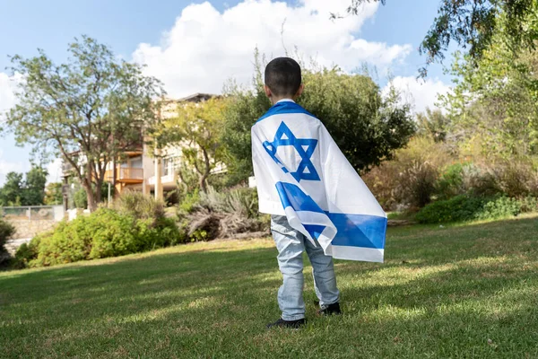 Israelische Flagge Gehülltes Kind Steht Und Blickt Auf Israelische Siedlung lizenzfreie Stockbilder