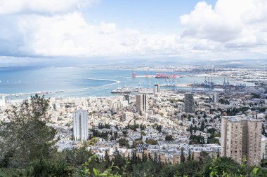 Hayfa 'nın panoramik görüntüsü şehir sahil şeridini, konut binalarını ve hareketli liman faaliyetlerini yakalar. Bereketli yeşillik kentsel yapılar ve canlı mavi denizle çelişiyor..