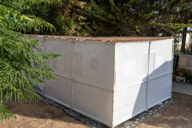 Geçici bir suka yemyeşil bir arka bahçede duruyor, doğal malzemelerle kaplı. Beyaz duvarlar, Sukkot şenlikleri sırasında aile ve arkadaşlar için davet edici bir alan oluşturuyor..