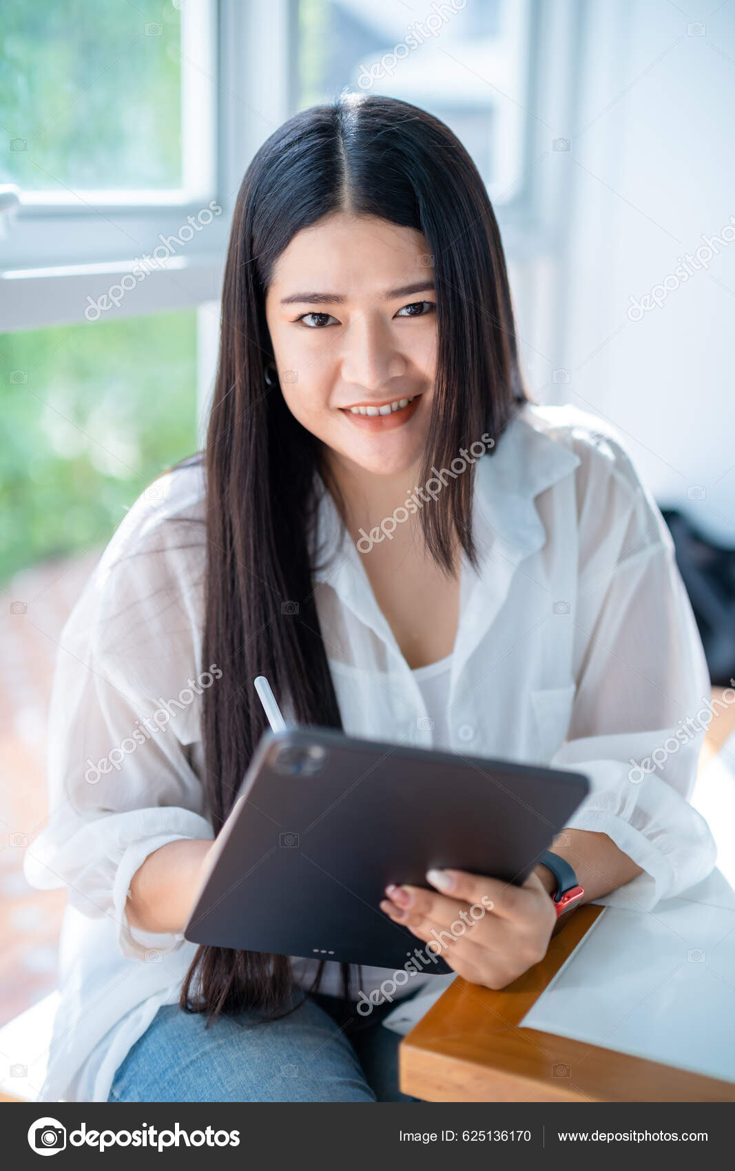 亚洲自由职业的女商人穿着时髦的说教服用平板电脑轻松地上网写博客用智能手机在咖啡店用笔记本——图库图片© Thinnapob #625136170