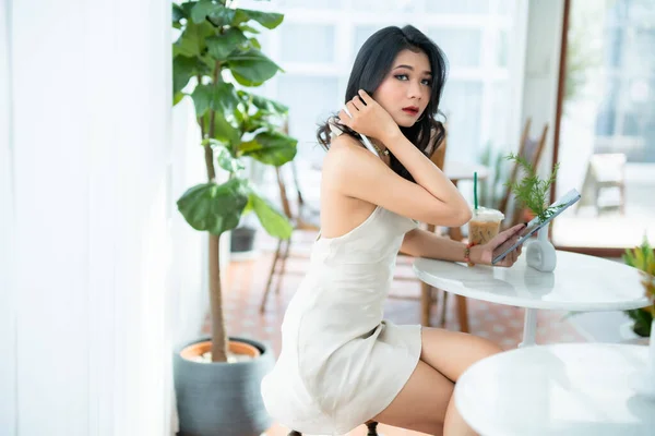 아름다운 아시아인 프리랜서 사업가들은 소매없는 드레스를 인터넷 커피숍에서 깅을하며 쇼핑을 — 스톡 사진
