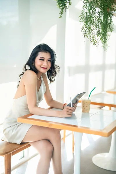 아름다운 아시아인 프리랜서 사업가들은 소매없는 드레스를 인터넷 커피숍에서 깅을하며 쇼핑을 — 스톡 사진