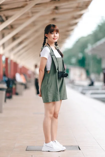 ポートレート若いアジアの女性の笑顔観光客の女の子が歩いて カメラを保持して鉄道のプラットフォームで撮影され 列車の旅を待ちますタイ 夏のリラックスした休暇コンセプト — ストック写真