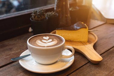 Sütlü sütlü sütlü sütlü sütlü sıcak kahve ve ahşap masanın üstünde ev yapımı çikolatalı kek ahşap masa. İş konsepti sırasında bir kafede kahvaltı olarak.