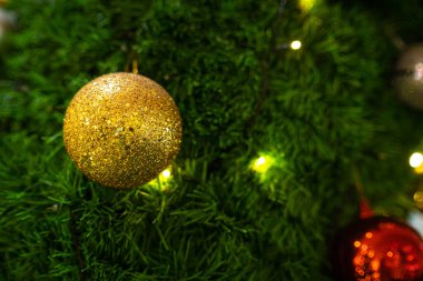 Mutlu Noel 'ler, renkli baloları, hediye kutularını ve Noel arkaplanındaki yeşil Noel ağacı dekorasyonunu Noel ve yeni yıl boyunca kutlayın..