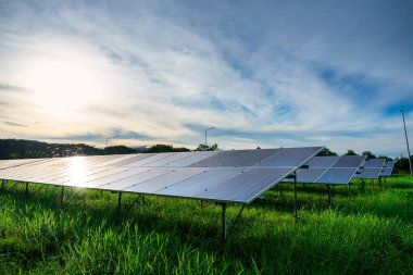 Fotovoltaik güneş enerjisi paneli dramatik gün batımı mavi gökyüzü arkaplanı, yeşil temiz Alternatif enerji kavramı.
