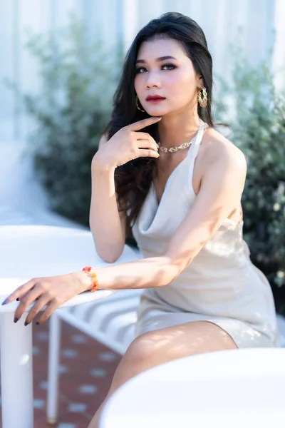 Portrait beautiful asian freelance Success people business woman fashion model in summer white sleeveless dress and coffee in cup in coffee shop.